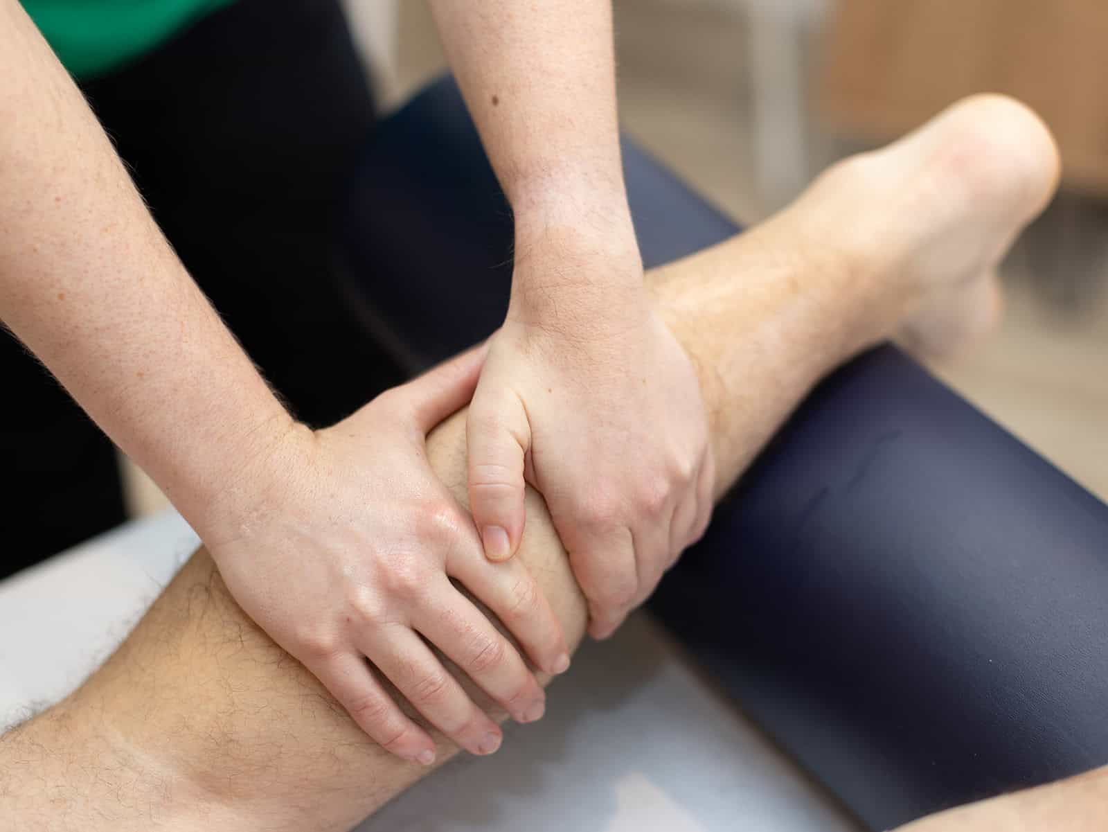 Close-up of lymphatic drainage massage on client’s calf for detox and circulation 