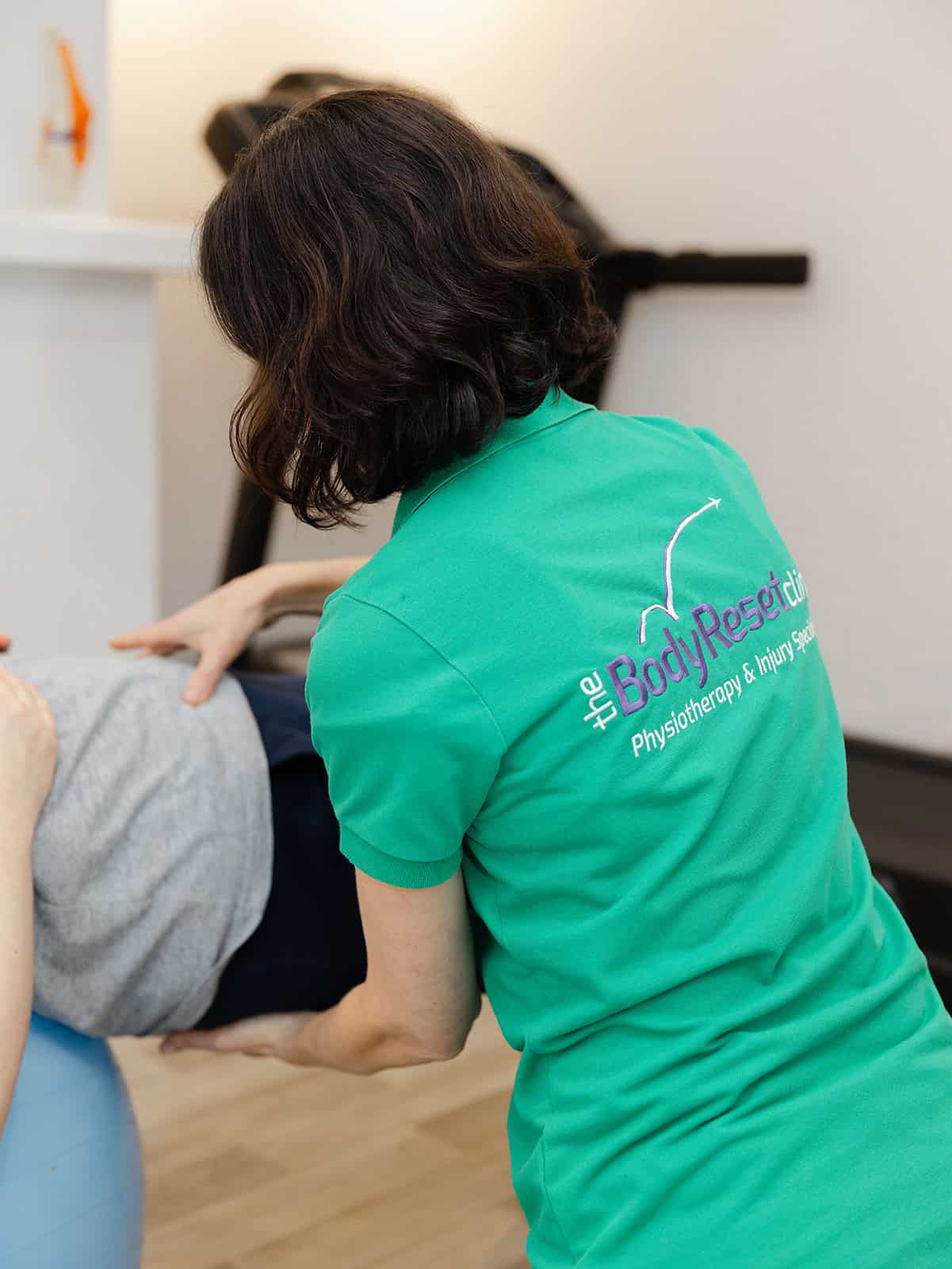 Pia Barrass assisting client on a yoga ball during a small bespoke Pilates session for rehabilitation and strength