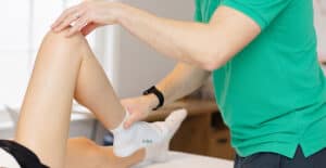therapist assessing knee pain and movement