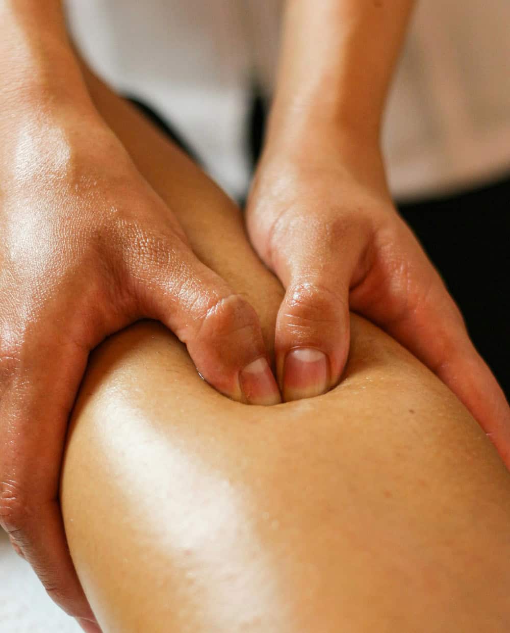 Close-up of lymphatic drainage massage on client’s calf for detox and circulation 