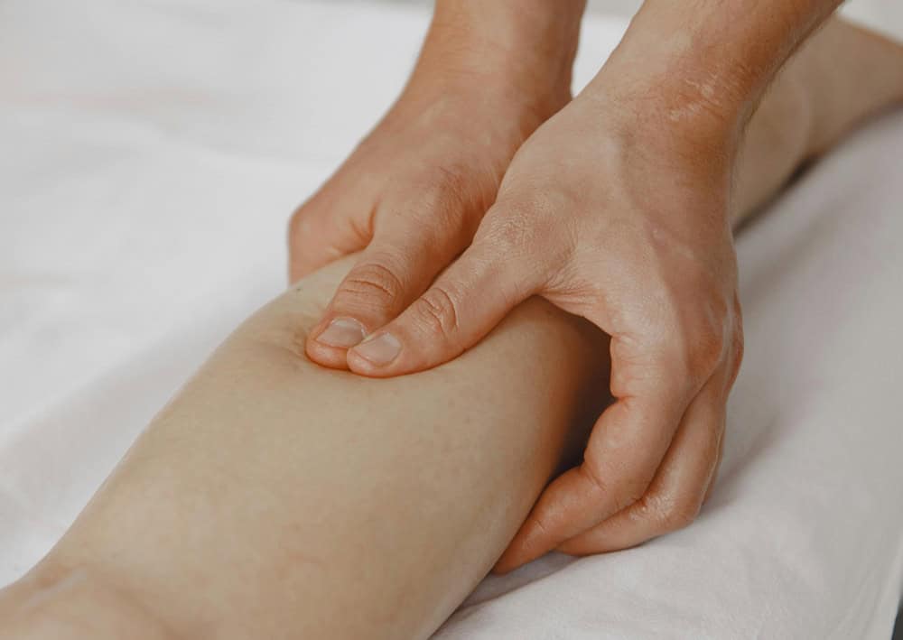 Close-up of lymphatic drainage massage on client’s calf for detox and circulation 